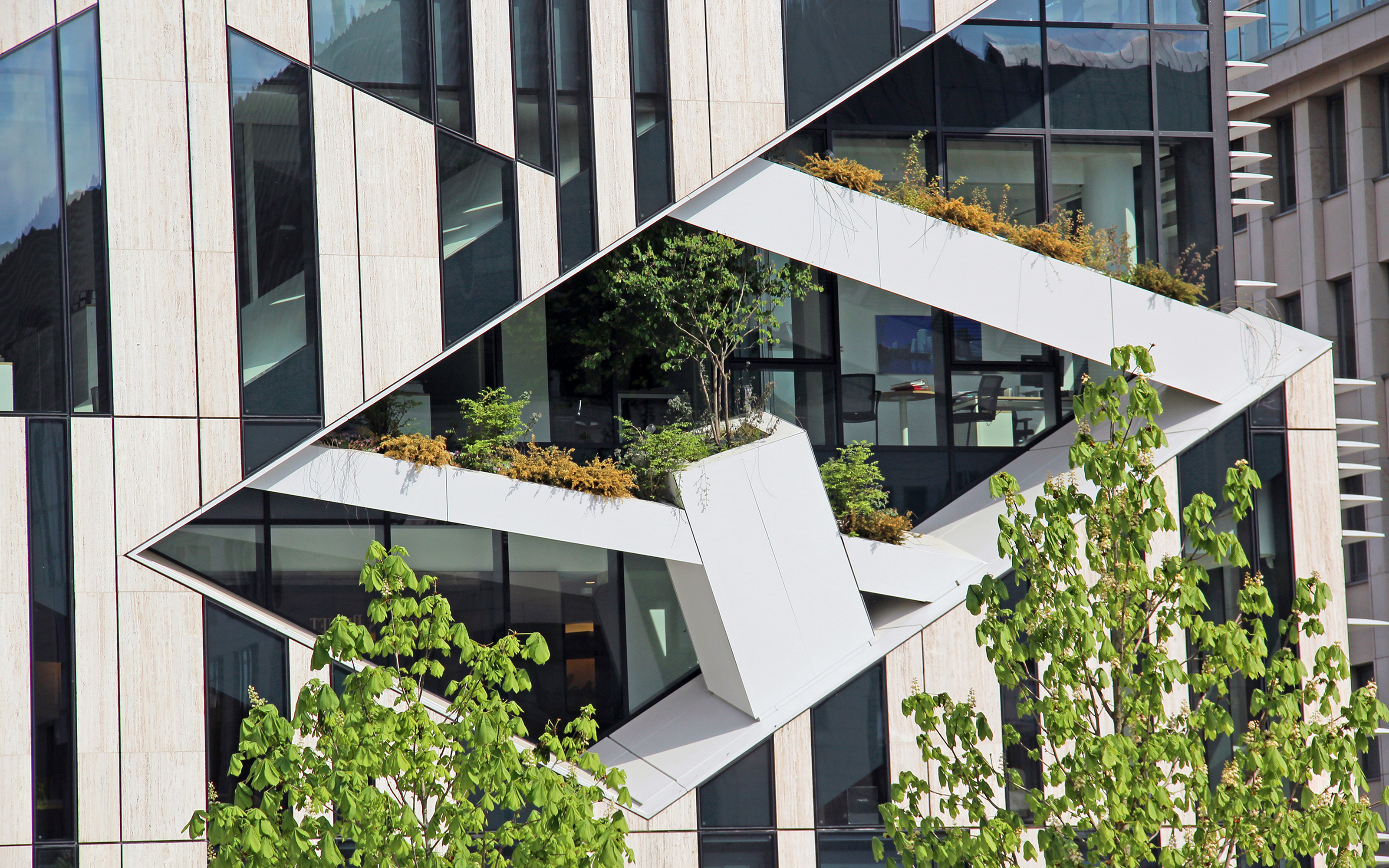 Façade with a geometrical pattern and planted cuts